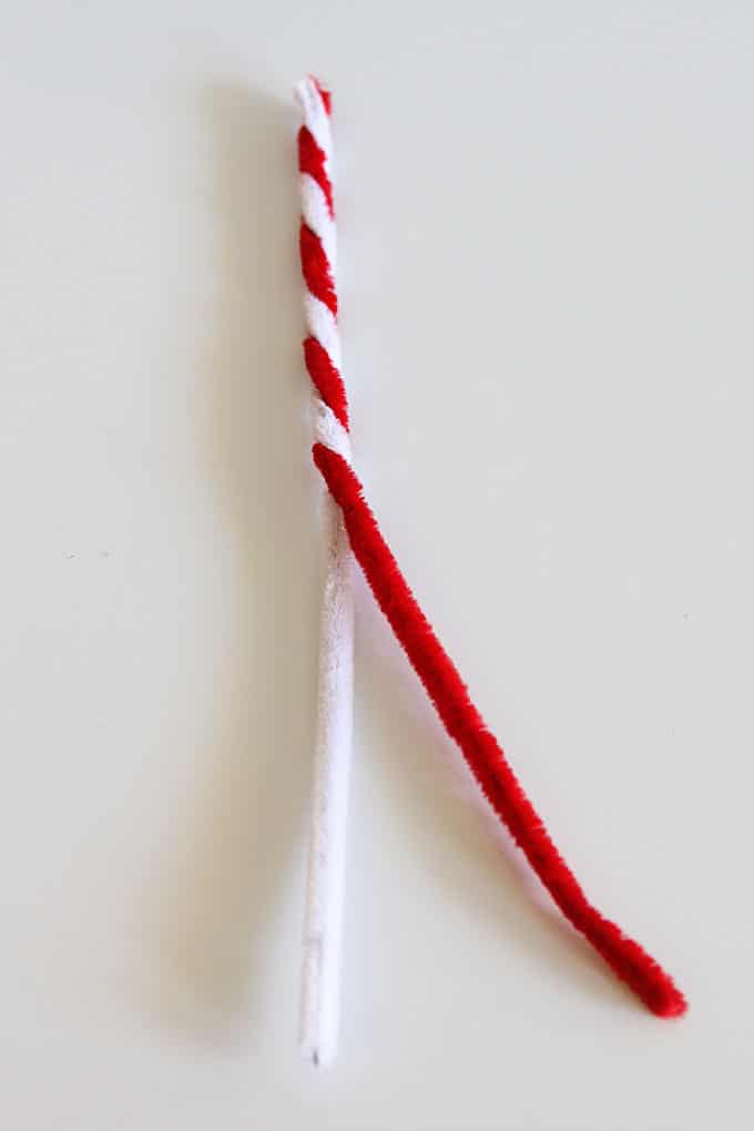 Twisting a red and a white pipe cleaner together.