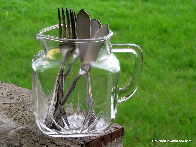 silverware in a glass pitcher