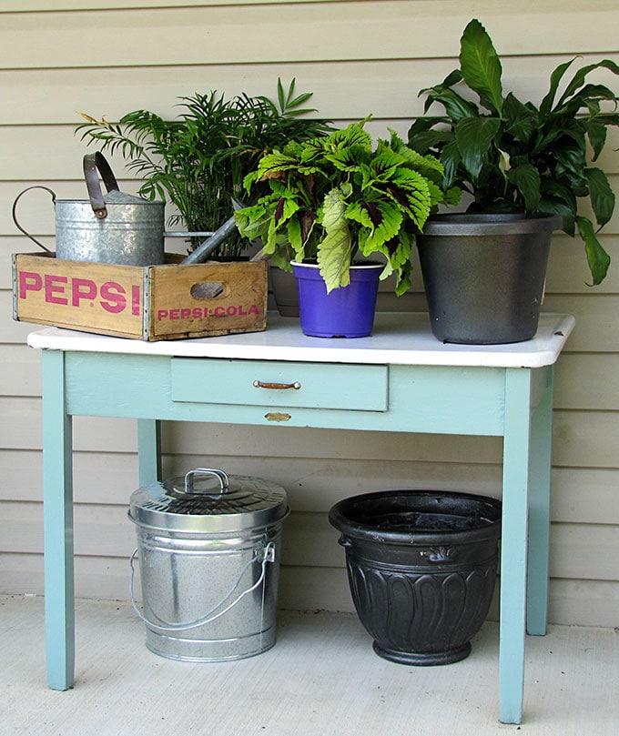 A vintage enamel top table doubles as a potting table or bench.