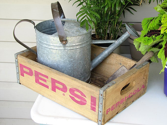 A vintage enamel top table doubles as a potting table or bench.