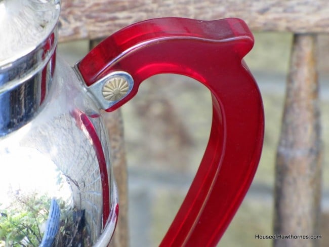 Red Bakelite handle on a cocktail shaker.