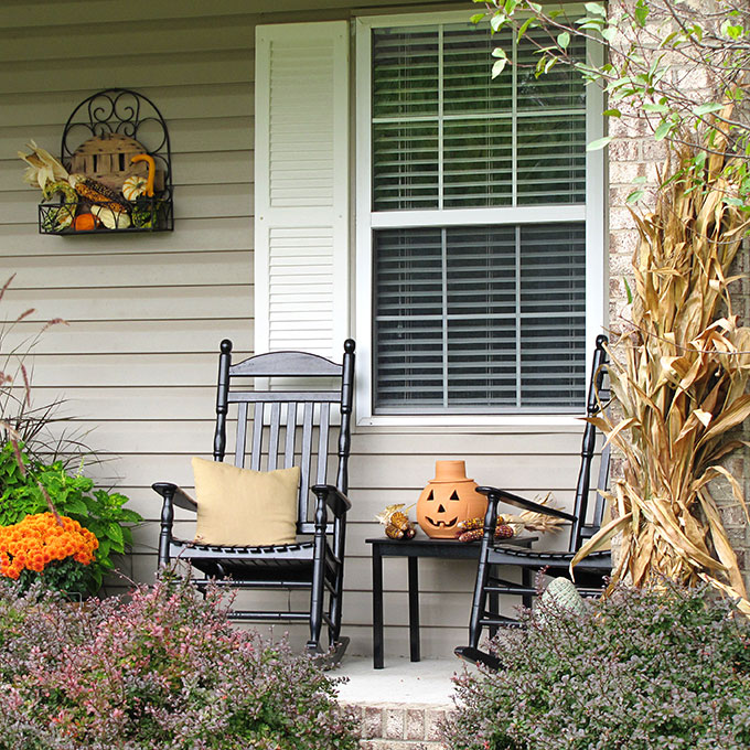 Fun fall front porch decor using traditional cornstalks, Indian corn, gourds and mums along with the unexpected - a vintage toy truck loaded with pumpkins.