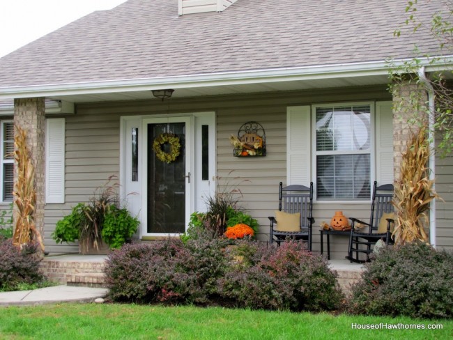 Fun fall front porch decor using traditional cornstalks, Indian corn, gourds and mums along with the unexpected - a vintage toy truck loaded with pumpkins.