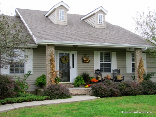 Fun fall front porch decor using traditional cornstalks, Indian corn, gourds and mums along with the unexpected - a vintage toy truck loaded with pumpkins.