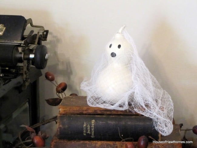 Gourd ghost setting on a stack of books.