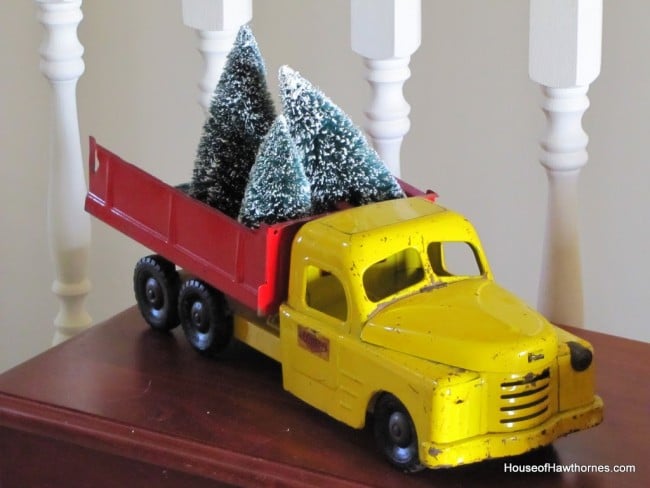 Vintage yellow Structo truck with Christmas trees in the red bed.