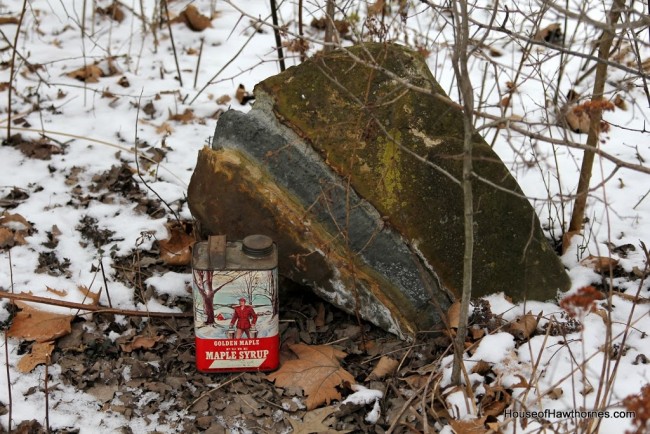 Vintage syrup tin setting next to a rock.