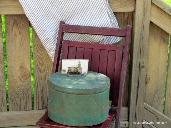 Red folding chair with green tin on top.