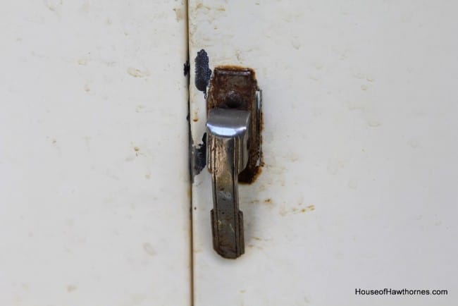 Rusty latch on metal cabinet.