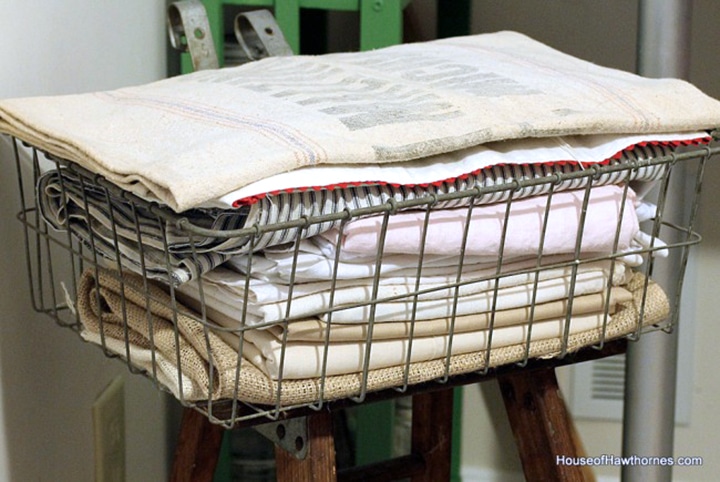 Farmhouse wire basked with a stack of linen in it.