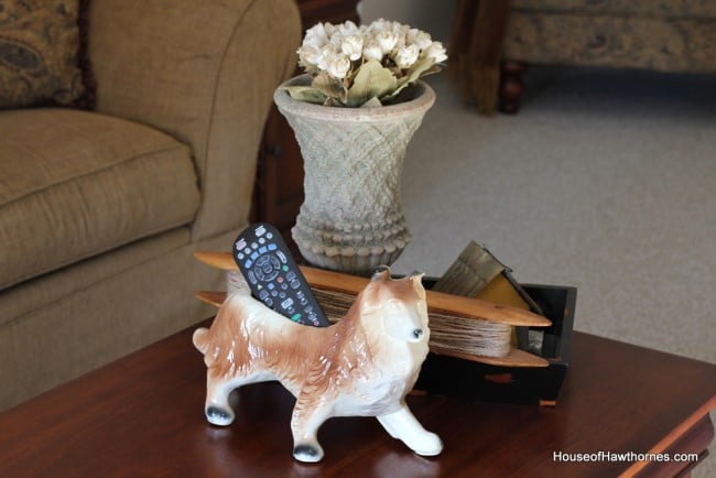 Vintage dog planter used as a remote control holder.