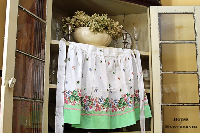 Vintage half apron with flowers and green trim.