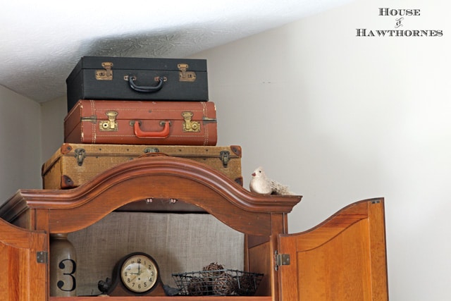 3 vintage suitcases on top of a cabinet for an eclectic decorating style.