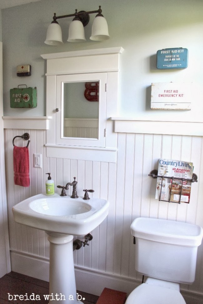 Vintage first aid kits used in bathroom decor.