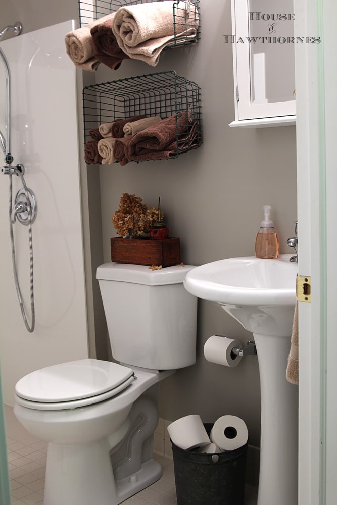 Industrial style bathroom with vintage locker baskets and oil cans