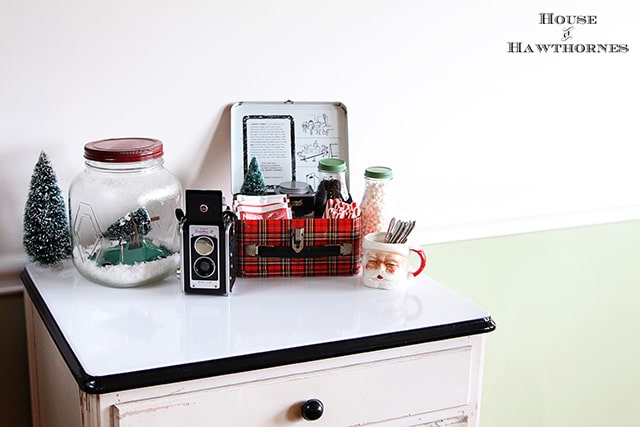 A vintage inspired hot cocoa station for the holidays. Cute ideas for a Christmas display! Love the old Santa mug, vintage camera and plaid school lunchbox!