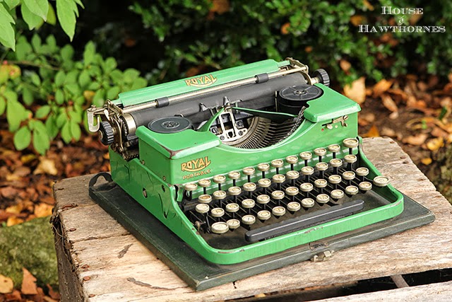 Green 1937 portable Royal typewriter sitting on a crate.