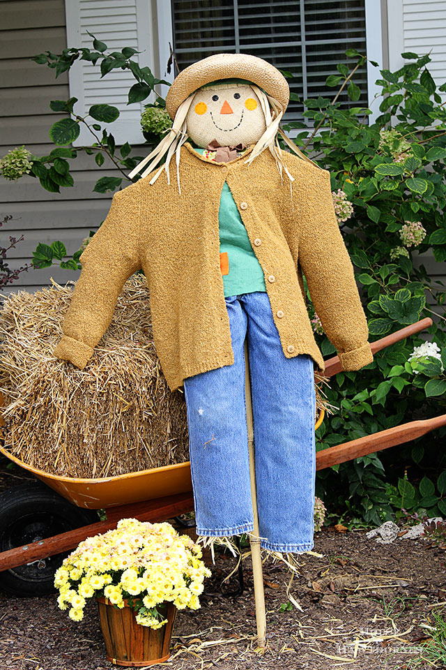 DIY scarecrow tutorial for fall decor. She used an inexpensive JoAnn Fabrics' stick scarecrow and thrift store clothing to doll her up!