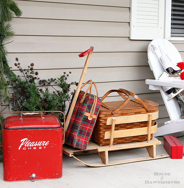 Fun holiday front porch ideas are shown, including chalk painted skis, vintage Thermoses and plaid decor for Christmas. And most of the items were found at thrift stores and estate sales.