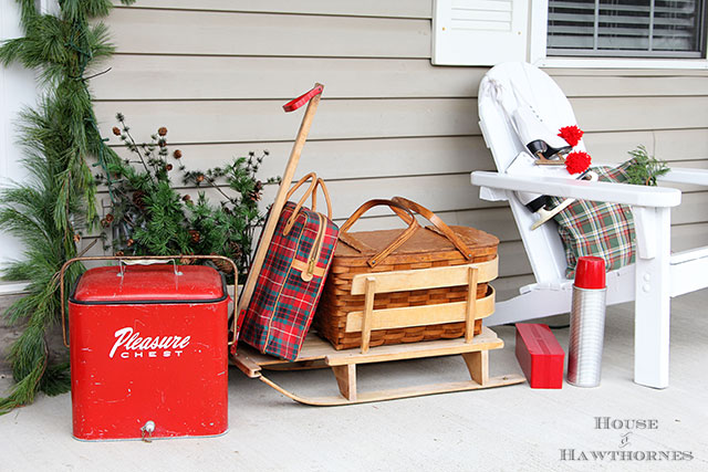 Fun holiday front porch ideas are shown, including chalk painted skis, vintage Thermoses and plaid decor for Christmas. And most of the items were found at thrift stores and estate sales.