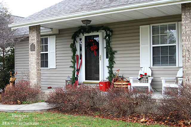 Fun holiday front porch ideas are shown, including chalk painted skis, vintage Thermoses and plaid decor for Christmas. And most of the items were found at thrift stores and estate sales.