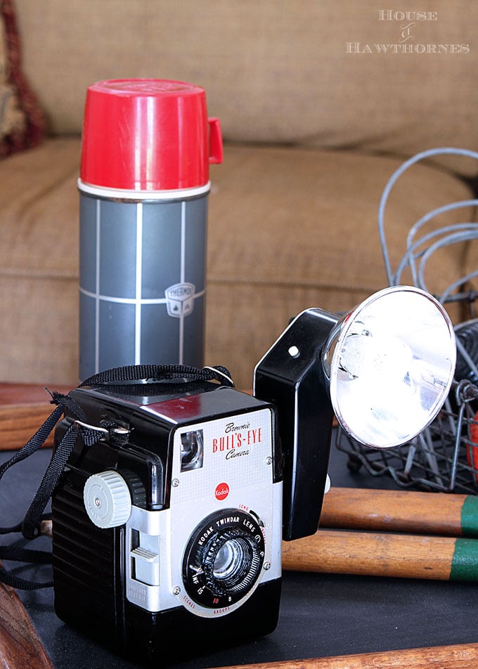 Vintage Brownie Bulls Eye Camera as part of a rustic vintage eclectic style summer home decor tour including vintage thermoses, cameras, typewriter and vintage croquet and badminton equipment.