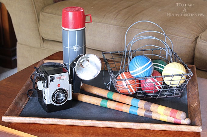 A rustic vintage eclectic style summer home decor tour including vintage thermoses, cameras, typewriter and vintage croquet and badminton equipment.