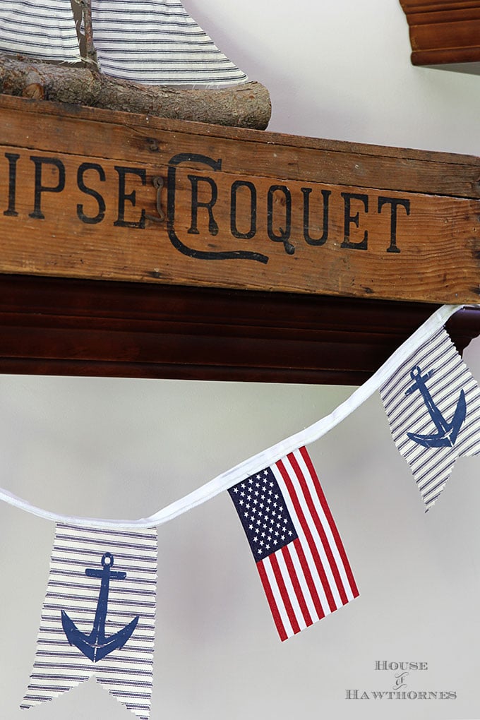 A super easy DIY patriotic banner tutorial. Anchors, flags and sailboats combine for a nautical Fourth Of July home decor style or any patriotic holiday.