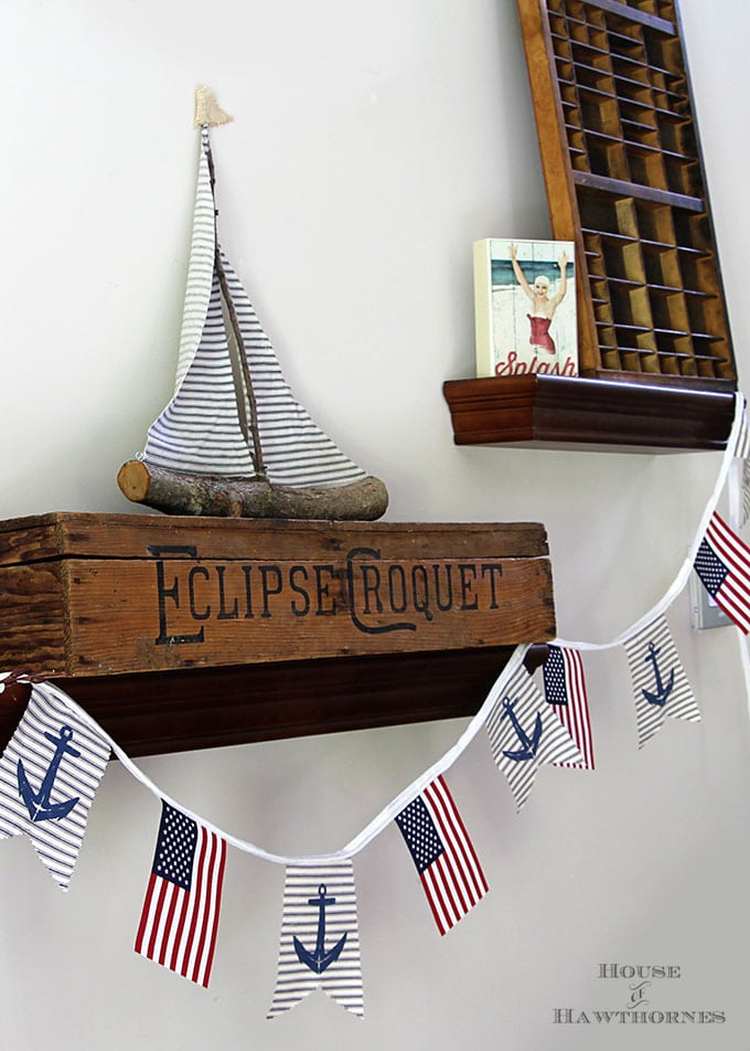 A super easy DIY patriotic banner tutorial. Anchors, flags and sailboats combine for a nautical Fourth Of July home decor style or any patriotic holiday.