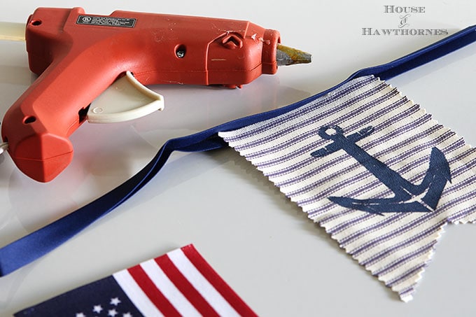 A super easy DIY patriotic banner tutorial. Anchors, flags and sailboats combine for a nautical Fourth Of July home decor style or any patriotic holiday.