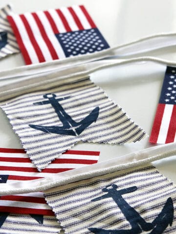 A super easy DIY patriotic banner tutorial. Anchors, flags and sailboats combine for a nautical Fourth Of July home decor style or any patriotic holiday.