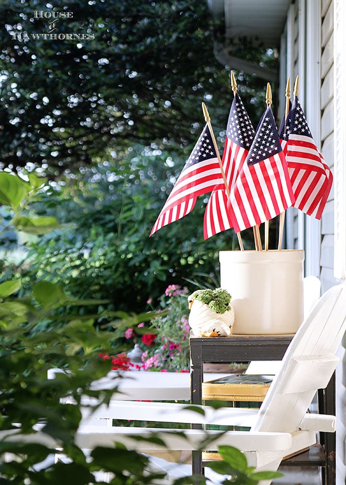 Summer porch decorating ideas and inspiration using farmhouse touches, vintage items, plenty of annual flowers and a healthy dose of patriotic decor.