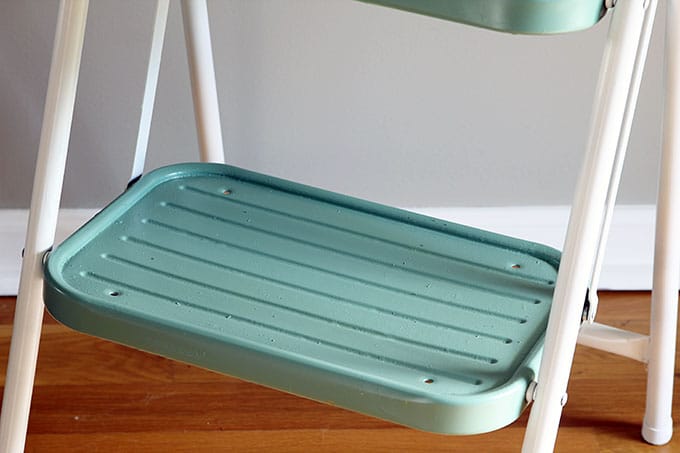 A yard sale makeover using spray paint to update a vintage step stool into a work of art. OK, that may be going a bit far, but it is a cute DIY project.