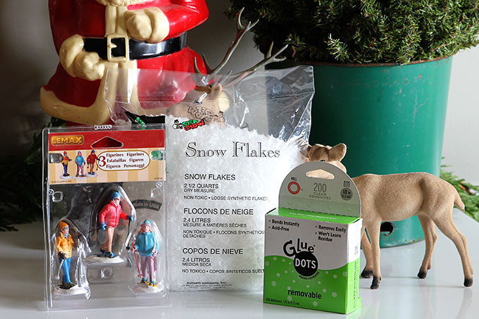 Supplies to make a waterless snow globe - holiday figurines, fake snowflakes and glue dots.
