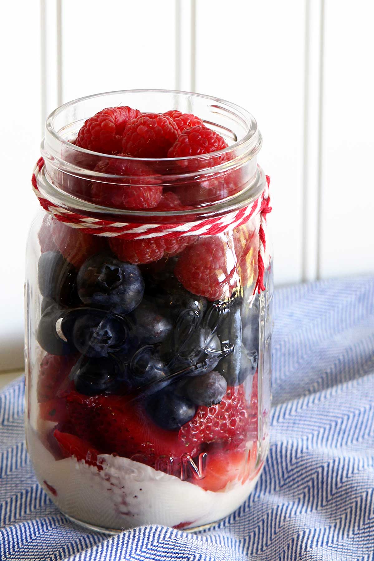Strawberries, blueberries and raspberries in a mason jar.