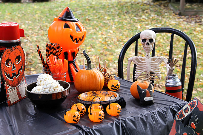 A traditional Halloween party with orange and black decor including blow molds and vintage inspired Halloween decorations.