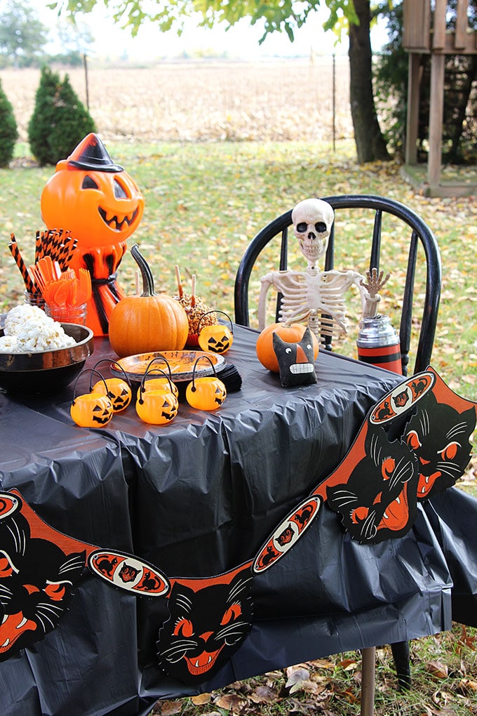 A traditional Halloween party with orange and black decor including blow molds and vintage inspired Halloween decorations.