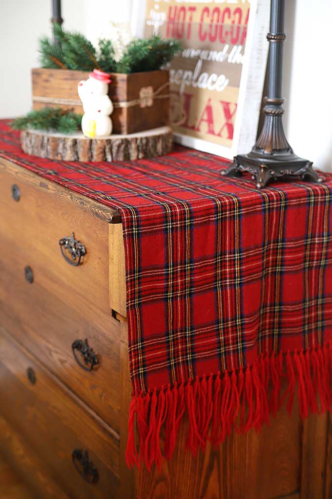 Plaid scarf repurposed into table runner for Christmas