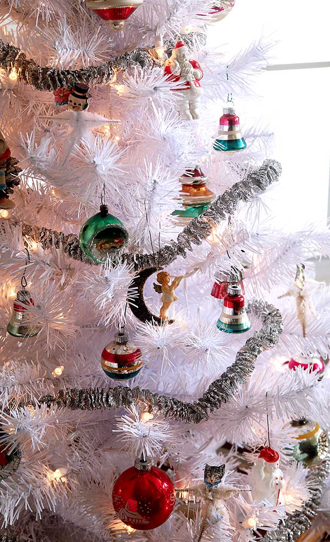 Vintage Shiny Brite ornaments hanging on a white Christmas tree.