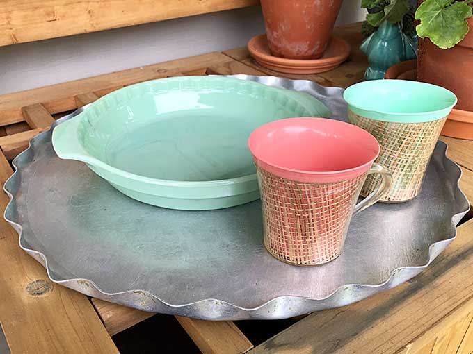 hammered aluminum serving tray, a Fire-King jadeite colored pie pan and two vintage melmac coffee mugs