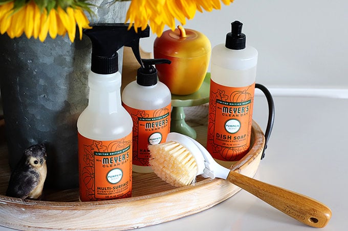 Grove cleaning supplies for fall setting on a wooden tray.