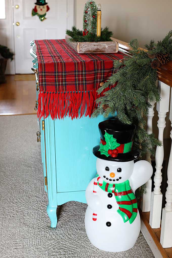 Snowman blowmold with red and green scarf and candy cane.