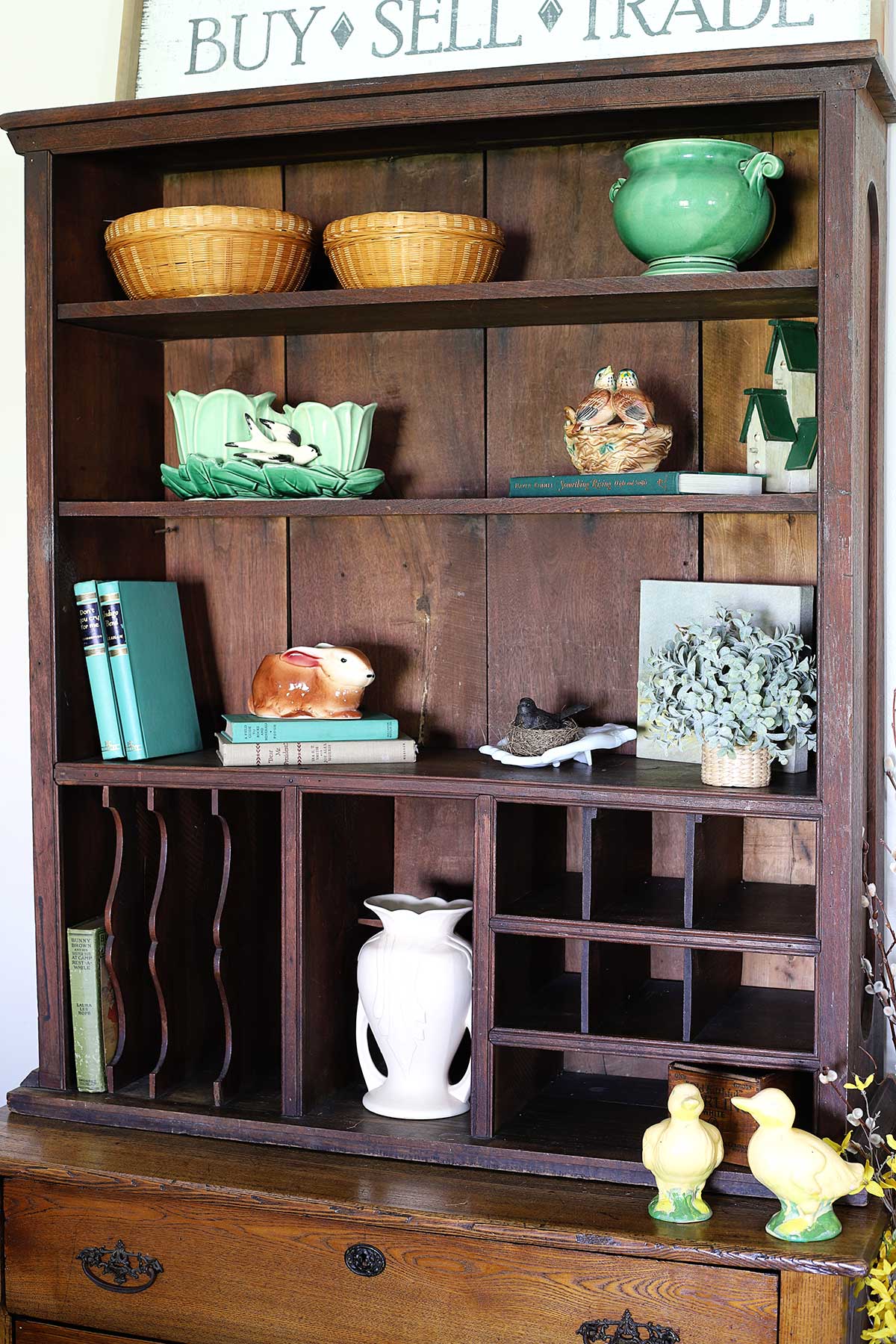 adding spring decor on the bookshelf