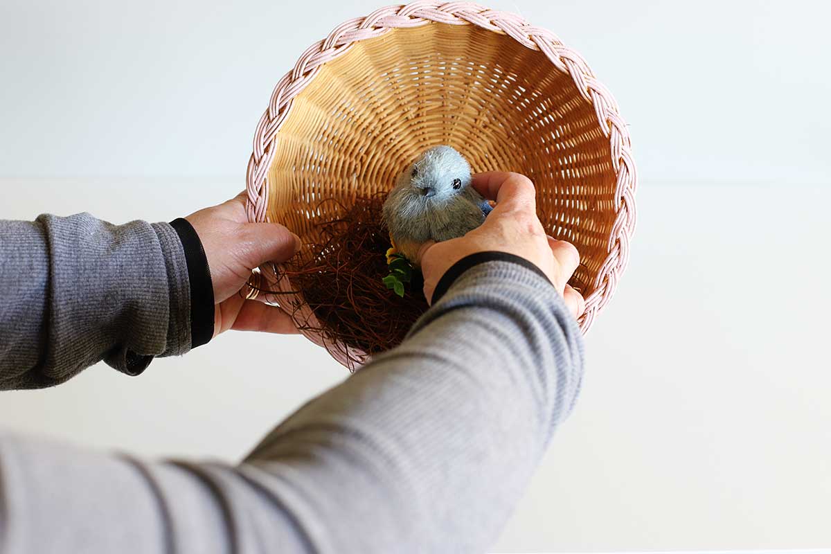 gluing bird to decorative nest