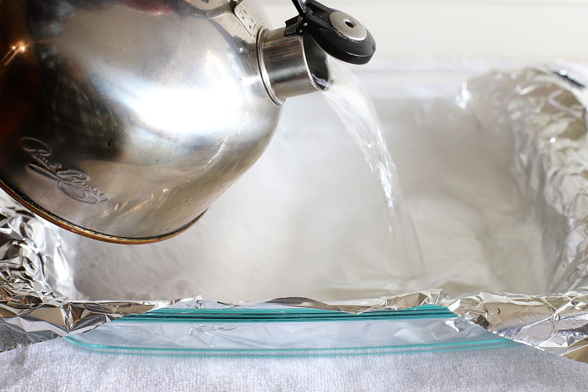 pouring hot water into pan lined with aluminum foil