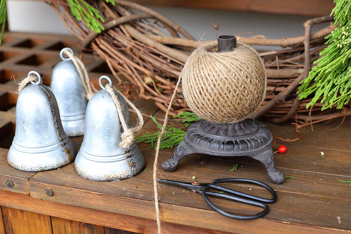 using twine to hang bells on wreath