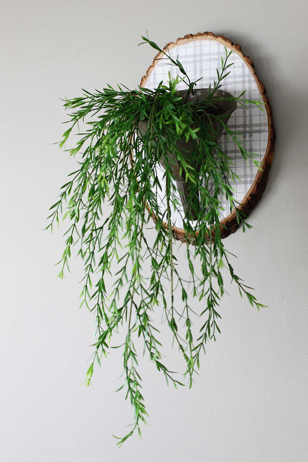 galvanized funnel repurposed into wall art by hanging it on a wood slice painted with plaid pattern