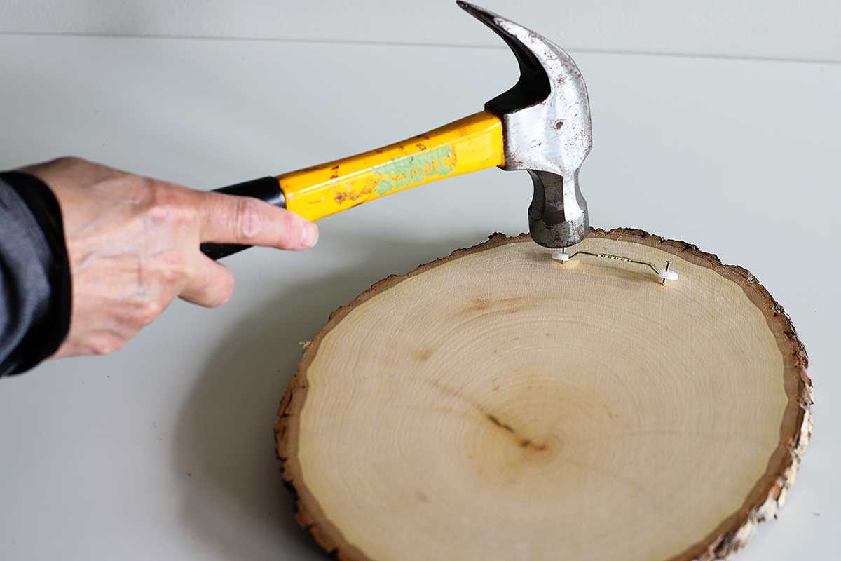 attaching the sawtooth hanger to the back of a wood slice