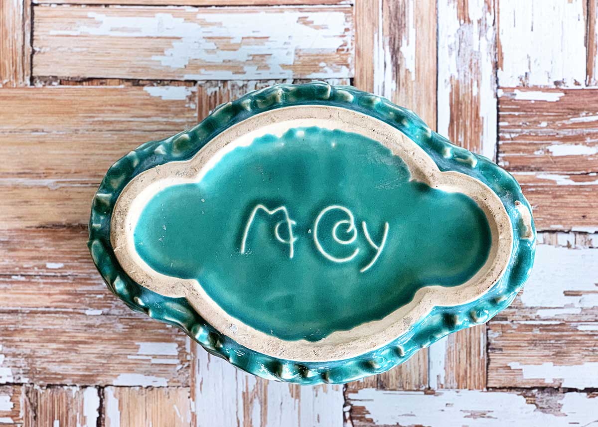 The McCoy Pottery mark on the bottom of a turquoise planter. 