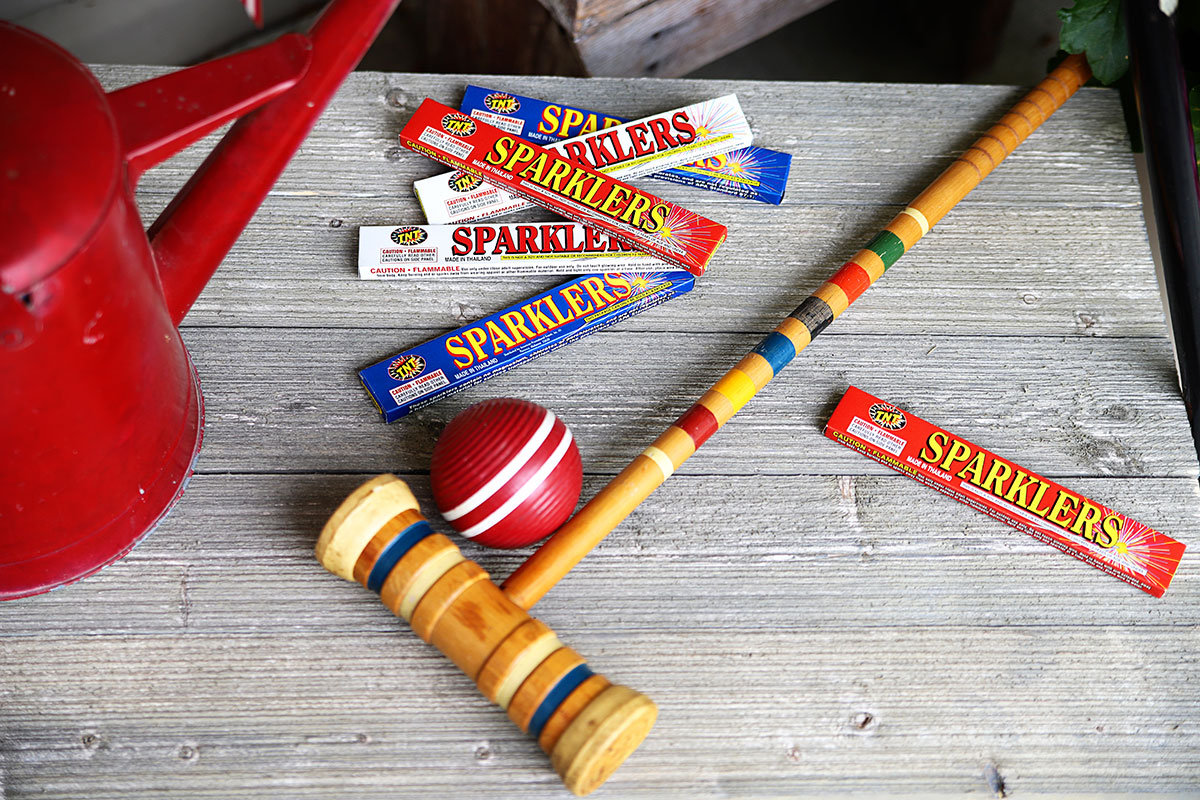 Croquet mallet and sparklers used as summer porch decor for 4th Of July.